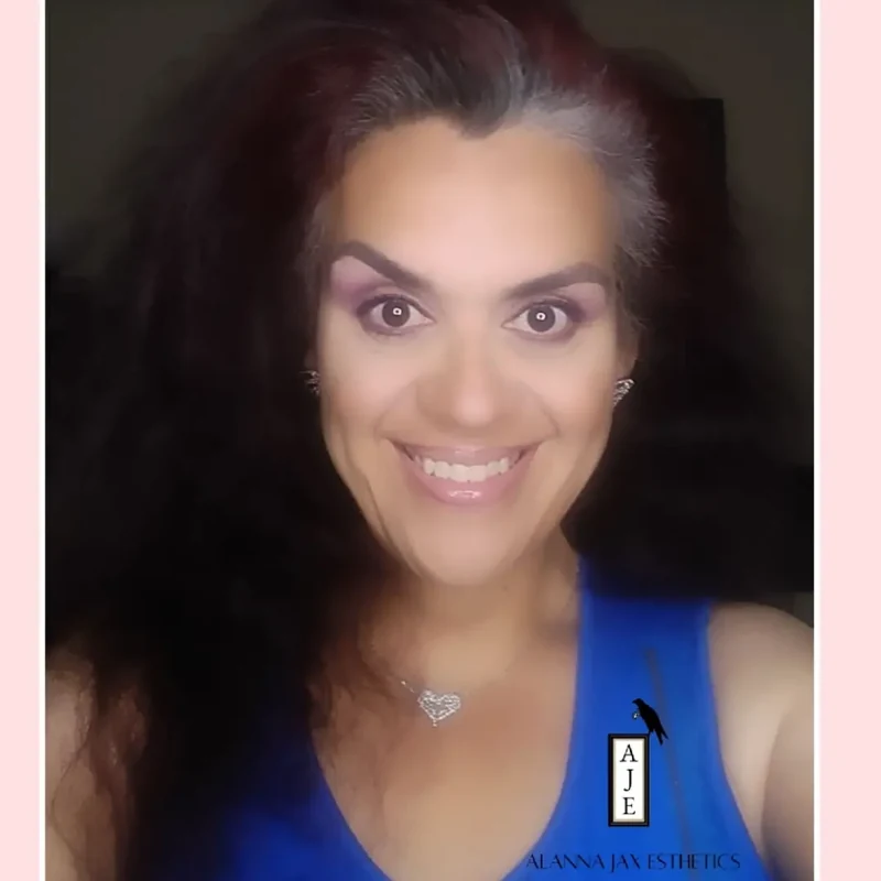 Maggie smiling in a blue top.